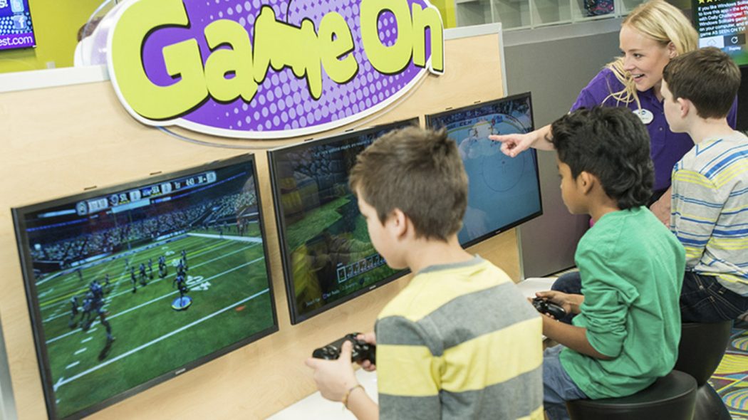Kids playing football game on a PlayStation at childcare center.