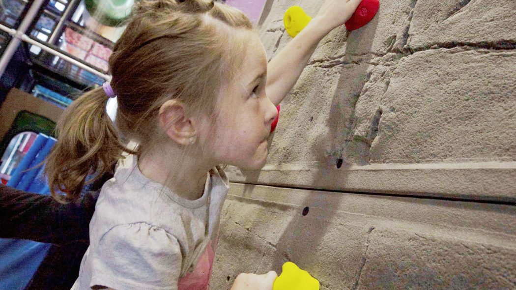 Girl Climbing on indoor climbing wall
