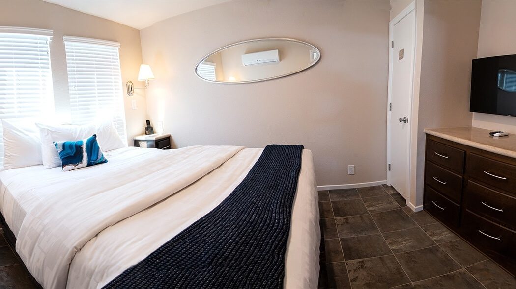 Panorama of bedroom with bed, tv and dresser unit